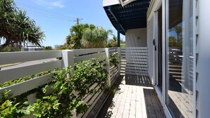 A building with a white exterior, a covered porch, and a white fence.