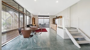 Ein modernes Interieur mit Essbereich, Küche und Treppe.