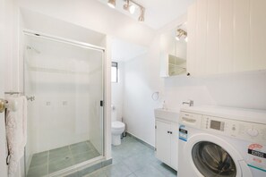A modern bathroom with a glass-enclosed shower, a toilet, and a Bosch washing machine. - 69 Mahogany Drive, Marcus Beach, Noosa Area (Marcus Beach)