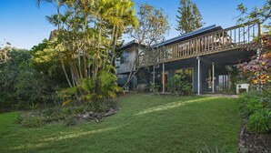 Una casa moderna con un espacio exterior cubierto y un césped cuidado.