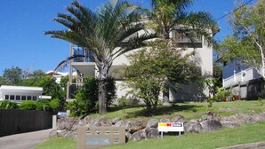 A modern two-story building with a balcony, surrounded by lush greenery and palm trees. - Unit 3 at 4 Pelican Street, Peregian Beach, Noosa Shire (Peregian Beach)