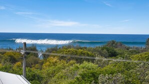A coastal view with a clear sky, waves, and dense greenery. - Unit 3 at 4 Pelican Street, Peregian Beach, Noosa Shire (Peregian Beach)