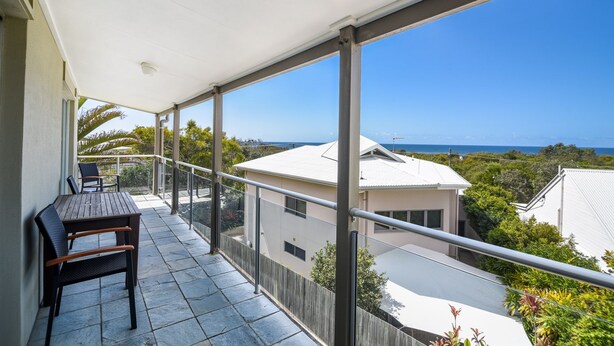 A balcony with a table and chairs, offering a view of the sea and surrounding buildings. - Unit 3 at 4 Pelican Street, Peregian Beach, Noosa Shire (Peregian Beach)