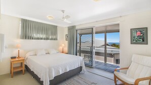 A bedroom with a bed, bedside tables, a chair, a balcony with a view, and a ceiling fan. - Unit 3 at 4 Pelican Street, Peregian Beach, Noosa Shire (Peregian Beach)