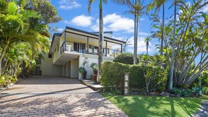 A modern two-story house with a paved driveway and lush tropical landscaping. - Nobs -1/44 Peregian Esplanade (Peregian Beach)