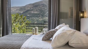 Une chambre à coucher avec un lit, des oreillers et une vue sur un paysage montagneux.
