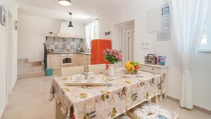 Una cocina con salpicadero de azulejos, una cafetera y una radio antigua.