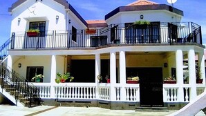 A two-story building with balconies, a satellite dish, and potted plants. - RESIDENCE BAOBAB LOFT (Morondava)