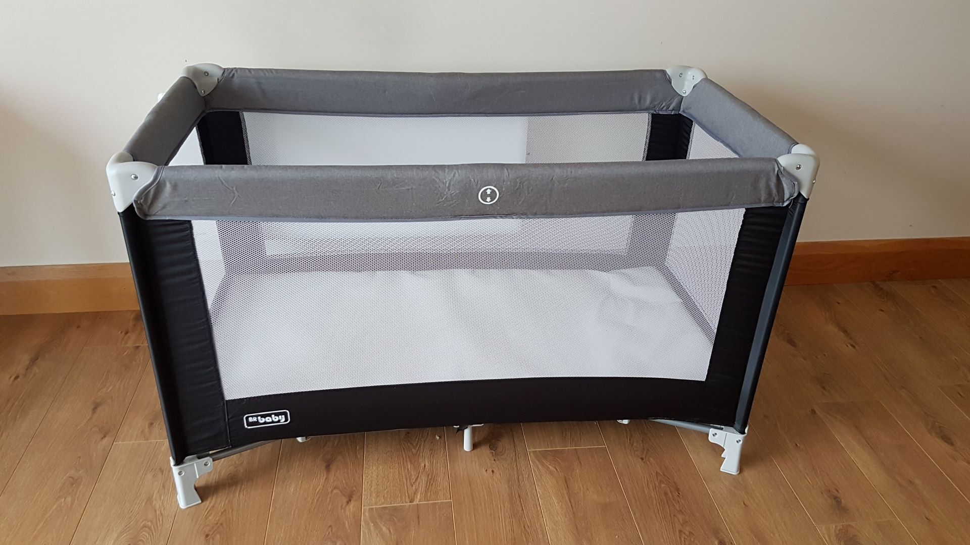 A portable baby playpen with a mesh top and a solid bottom, featuring a safety lock and wheels for mobility.
