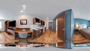 A modern interior with a kitchen, dining area, and bedroom. - WoodSpring Suites Davenport FL (Davenport)