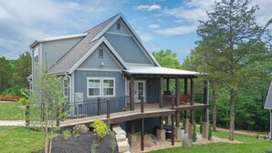 A two-story house with a covered porch and a stone foundation. - Bluff Cabin #5 -  Dual Masters, Game Room, Hot Tub, ADA access, NO Pet Cabin. (Kimberling City)
