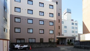 A multi-story hotel with a flat facade, multiple windows, and a visible entrance. - Tabist Rays Hotel Suisen (Miyazaki)