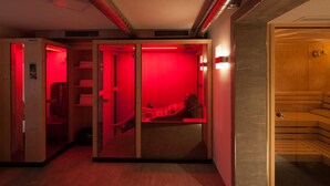 A sauna room with a wooden bench and a glass partition. - Krepperhütte (Volders)
