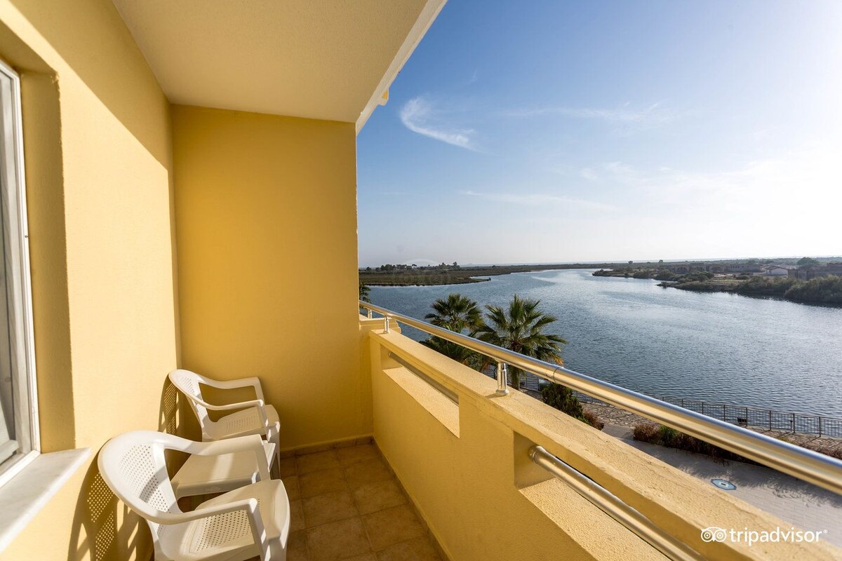 Un balcón con vista a un río y palmeras.