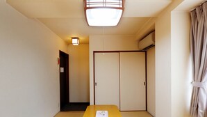 A traditional Japanese room with tatami flooring, a wooden table, and sliding doors. - Tabist Rays Hotel Yakata (Miyazaki)