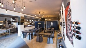 Un restaurante moderno con zona de bar, varias mesas y una pared que exhibe botellas de vino.