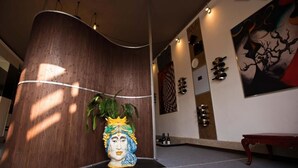 Un interior moderno con una pared de madera curva, una escultura decorativa en la cabeza, un banco y arte abstracto en la pared.