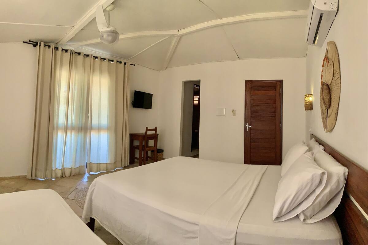 Ein Hotelzimmer mit einem Bett, einem Sessel, einem Fernseher und einer Tür.