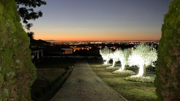 Un sentier pavé mène à un point de vue offrant une vue sur la ville au crépuscule.