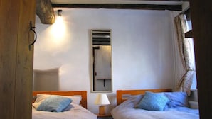 A room with two beds, a mirror, and a lamp. - sweet heART Tea Rooms Accommodation (Harrogate)