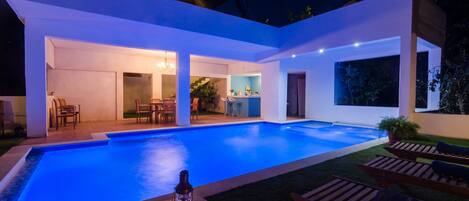 Una piscina al aire libre de temporada, una piscina infinita, sombrillas