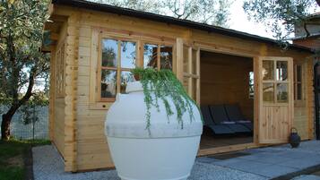 Una cabaña de madera con una maceta blanca grande al frente.