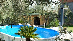 A swimming pool surrounded by olive trees and a wooden structure in the background. - Vacation home with swimming pool and hot tub relaxation and tranquility (Lamporecchio)