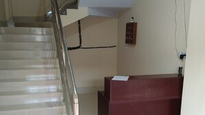Un escalier avec des rampes en métal menant à un comptoir d’accueil.