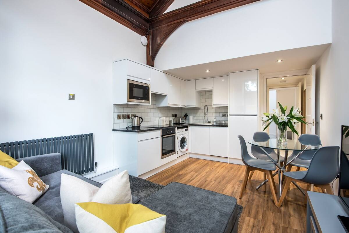 A modern kitchen with white cabinets, a microwave, and a built-in oven.