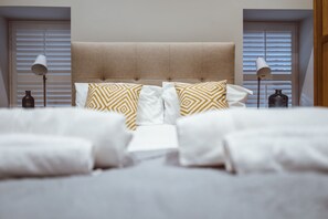 A neatly made bed with white and patterned pillows, a headboard, and two bedside lamps. - 52 Old Elvet (Durham)