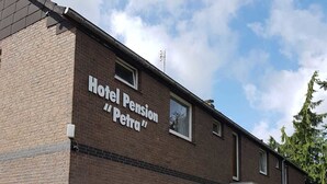 A two-story brick building with a sign reading "Hotel Pension Petra". - Hotel Pension Petra (Bad Zwischenahn)