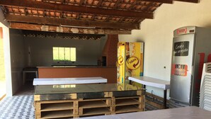 A room with a wooden table, a refrigerator, and a brick wall.