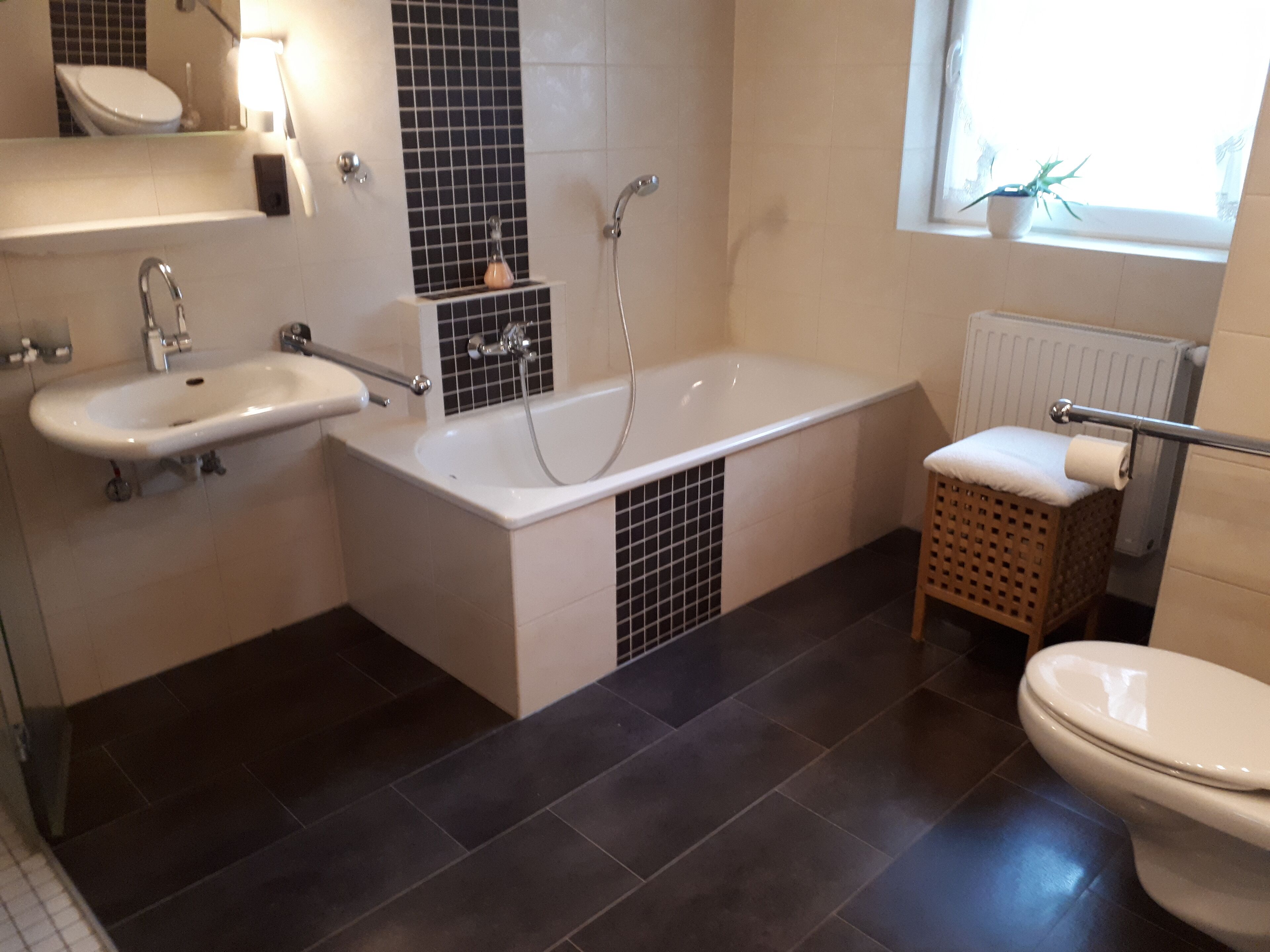 Un baño moderno con bañera, lavamanos e inodoro.