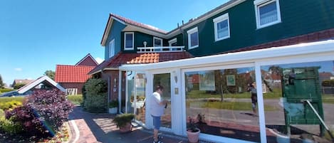 Ein Haus mit einer überdachten Veranda und einem Ziegelweg, der zum Eingang führt.