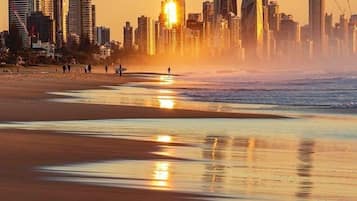 Une plage avec la silhouette d’une ville en arrière-plan.