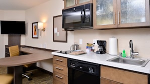 A compact kitchen with a microwave, coffee maker, and dishwasher.