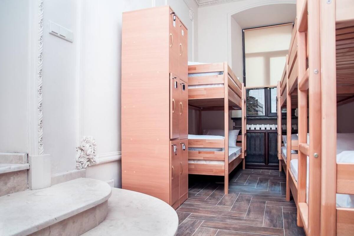 A room with bunk beds, a wooden cabinet, and a marble bench.