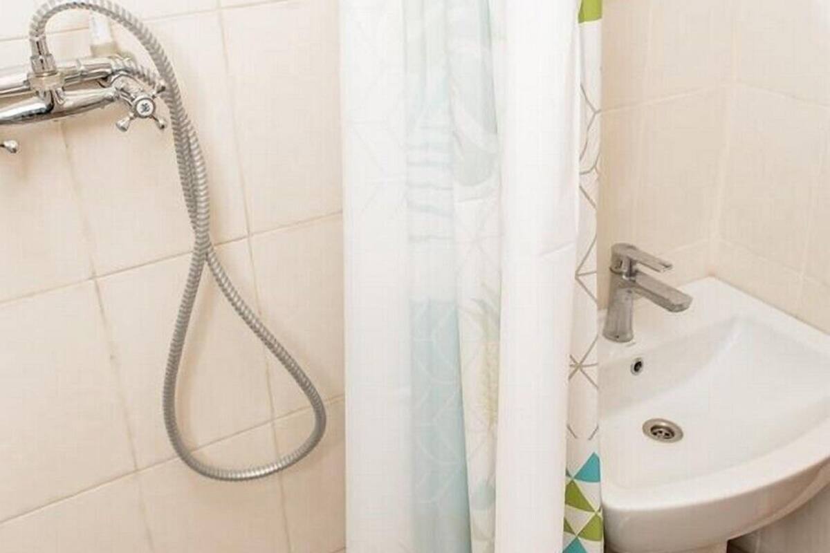 A bathroom with a shower, a sink, and a toilet.