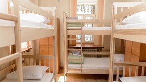 A bunk bed room with wooden frames and white bedding. - Globus Lipki Hostel (Kyiv)