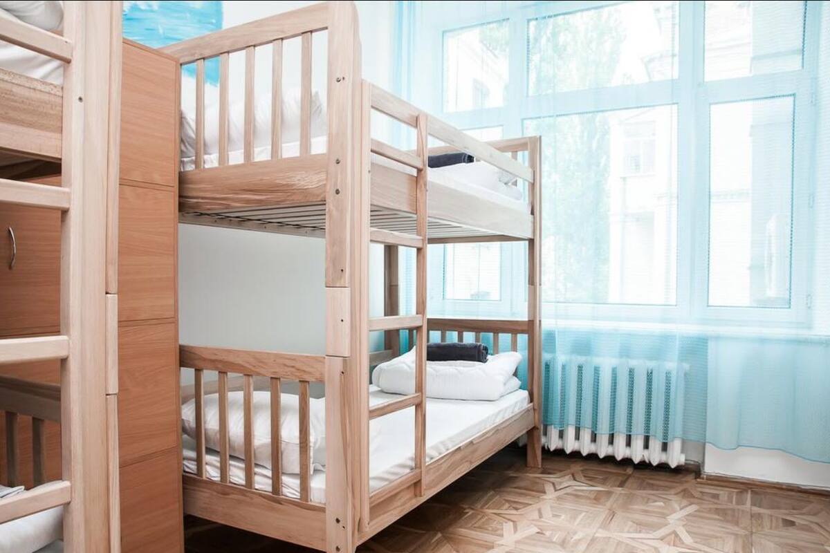 A bunk bed room with a window and radiator.