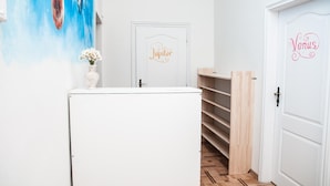 Un pasillo con una puerta blanca identificada con 'Jupiter', una puerta blanca identificada con 'Venus' y una pared con un mural de temática espacial.
