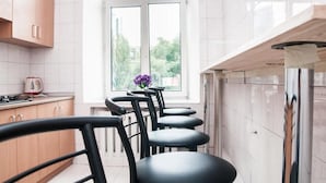 Una cocina moderna con armarios de madera, una ventana con vistas y una silla negra.