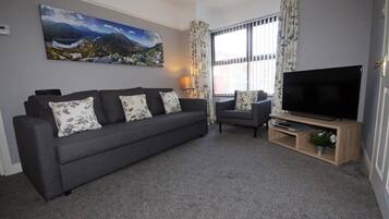 Habitación doble | Área de sala de estar | Televisión de pantalla plana