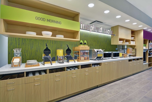 A modern breakfast bar with a 'GOOD MORNING' sign, a 'inspired table' sign, and various breakfast items and appliances.