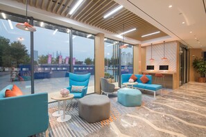 A modern lounge area with seating, large windows, and a view of the cityscape. - Holiday Inn Express Shanghai Jiading Center by IHG (Shanghai)