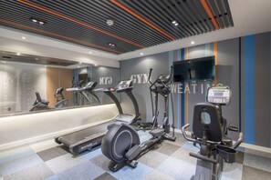 Ein Fitnessraum mit Laufbändern, Crosstrainern und einem stationären Fahrrad.