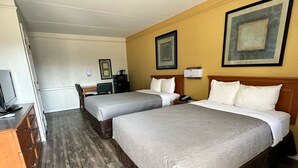 A hotel room with two beds, a desk, a chair, a television, and artwork on the walls. - Baymont by Wyndham Nacogdoches Near University (Nacogdoches)