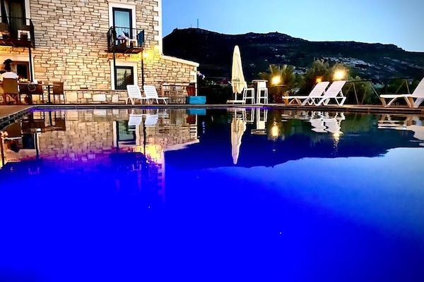 Een buitenzwembad, parasols voor strand/zwembad