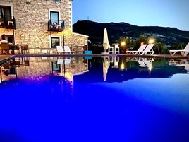 Una piscina al aire libre, sombrillas, tumbonas