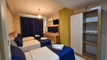 Quarto de hotel com duas camas, uma escrivaninha, um guarda-roupa e uma televisão.
